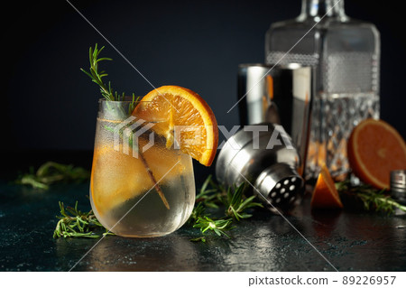 Cocktail gin tonic with ice, orange, and rosemary. Cocktail gin tonic with ice, orange, and rosemary. 89226957