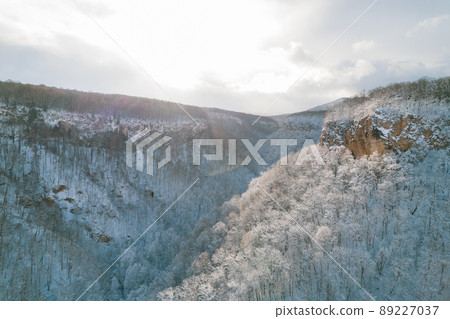 Aerial view of Plateau Lago-Naki mountain twisted road in the winter and driving car. Epic, snowy white winter and snow capped forest. Aerial view of Plateau Lago-Naki mountain twisted road in the winter and driving car. Epic, snowy white winter and snow capped forest. 89227037