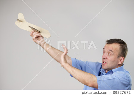 Fly fear. Man holding airplane in hand Fly fear. Man holding airplane in hand 89227671