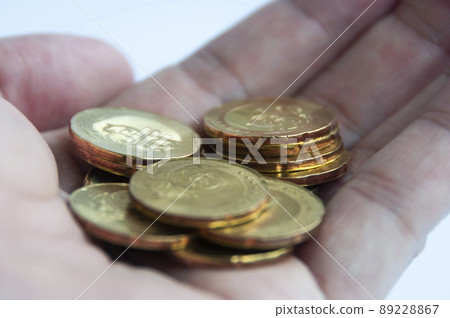 Hand showing gold coins with white background. Finance or saving concept 89228867
