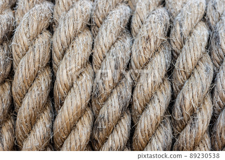 Close-up of a vertically wound rope on a textured background. Selective focus. Close-up of a vertically wound rope on a textured background. Selective focus. 89230538