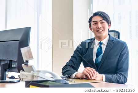A businessman staring at a PC monitor with a serious expression A businessman staring at a PC monitor with a serious expression 89231350
