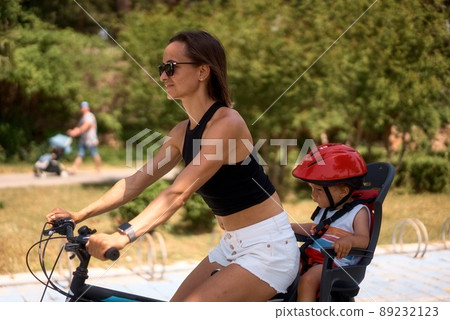 Young woman on a bicycle with little son 89232123