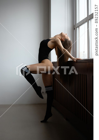 Sensual topless lady standing near window at home Sensual topless lady standing near window at home 89232157