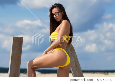 Beautiful woman in swimsuit on beach 89232200