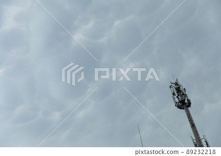 Cell phone transmission tower against a background of storm clouds. 89232218