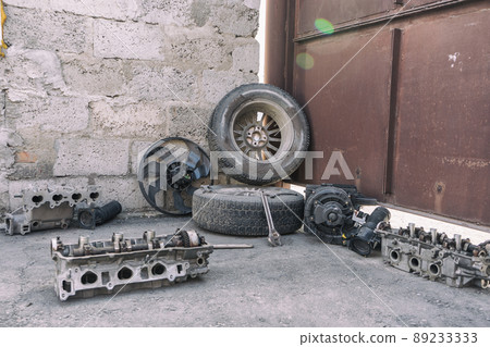 auto parts lie on asphalt in courtyard of private house auto parts lie on asphalt in courtyard of private house 89233333