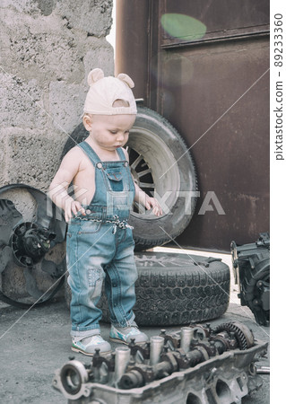 one year old baby playing mechanic among auto parts one year old baby playing mechanic among auto parts 89233360