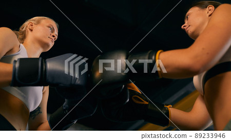 From below horizontal shot of two Caucasian women starting sparring match greeting each other From below horizontal shot of two Caucasian women starting sparring match greeting each other 89233946