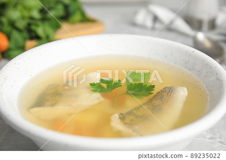 Delicious fish soup in bowl on table, closeup view Delicious fish soup in bowl on table, closeup view 89235022