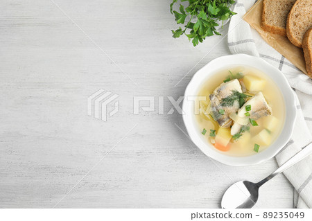 Delicious fish soup served on white wooden table, flat lay. Space for text Delicious fish soup served on white wooden table, flat lay. Space for text 89235049