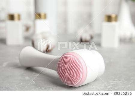 Modern face cleansing brush on light grey marble table. Cosmetic accessory Modern face cleansing brush on light grey marble table. Cosmetic accessory 89235256