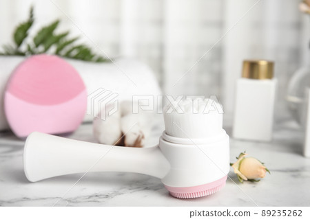 Modern face cleansing brush on marble table. Cosmetic accessory 89235262