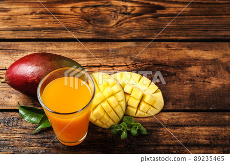 Fresh delicious mango drink on wooden table Fresh delicious mango drink on wooden table 89235465
