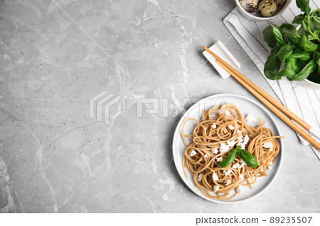 Tasty buckwheat noodles with chopsticks on light grey table, flat lay. Space for text Tasty buckwheat noodles with chopsticks on light grey table, flat lay. Space for text 89235507