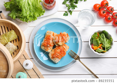 Delicious cabbage rolls served on white wooden table, flat lay 89235551