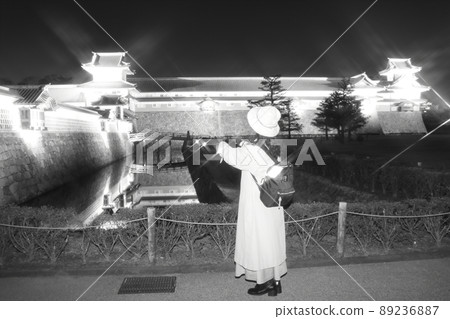 一個女人獨自旅行在金澤看燈火通明的城堡的殘像 89236887