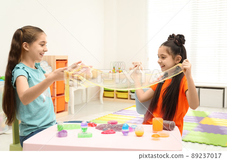 Happy girls playing with slime in room 89237017