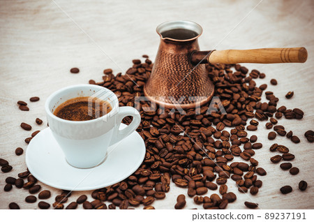 Coffee turk and cup of coffee on burlap background. coffee beans isolated on white background. roasted coffee beans Coffee turk and cup of coffee on burlap background. coffee beans isolated on white background. roasted coffee beans 89237191