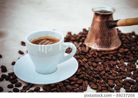 Coffee turk and cup of coffee on burlap background. coffee beans isolated on white background. roasted coffee beans Coffee turk and cup of coffee on burlap background. coffee beans isolated on white background. roasted coffee beans 89237208