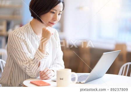 一位年輕女子在咖啡館裡盯著電腦屏幕 89237809