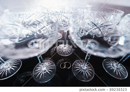 Bridal details - Wedding rings while bride getting ready before the ceremony - Vintage crystal wine glasses Bridal details - Wedding rings while bride getting ready before the ceremony - Vintage crystal wine glasses 89238323