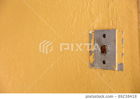 Old elevator call button with grungy pattern in a soviet building in post-soviet Riga, Latvia 89238418