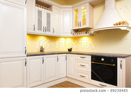 White empty kitchen with light white furniture - Warm lights and nicely decorated wood White empty kitchen with light white furniture - Warm lights and nicely decorated wood 89238485