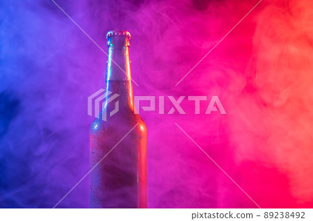 Glass bottle of beer in blue pink mist Glass bottle of beer in blue pink mist 89238492