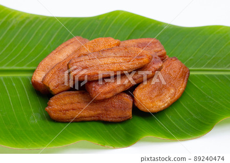 Sun dried bananas on leaf on white background. Sun dried bananas on leaf on white background. 89240474
