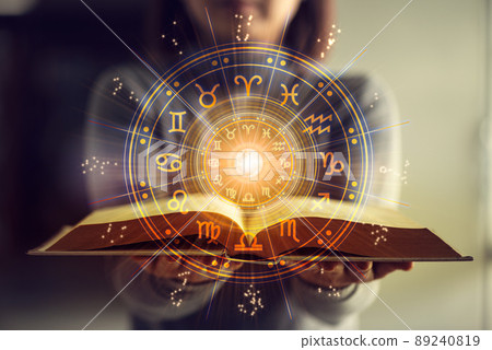 Woman holding a astrology book. Astrological wheel projection, choose a zodiac sign. Astrology esoteric concept. 89240819