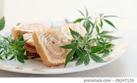 Sweet roll with marijuana oil on white plate. Cannabis kitchen Sweet roll with marijuana oil on white plate. Cannabis kitchen 89247129
