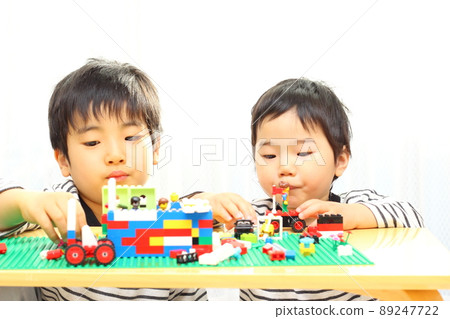 Brothers playing blocks at the table Brothers playing blocks at the table 89247722