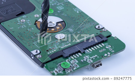 the hard drive from the computer is drilled with a large drill, macro 89247775