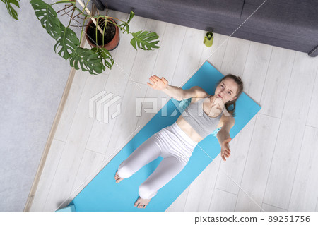 Girl during workout with myofascial roller. Woman uses foam massage roller massaging muscle. Girl during workout with myofascial roller. Woman uses foam massage roller massaging muscle. 89251756