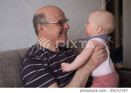 Grandfather holding a caucasian 8 month baby girl 89252587