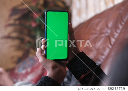 young man hand using smart phone with green screen lying on sofa young man hand using smart phone with green screen lying on sofa 89252739