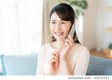 中間女人在房間裡操作智能手機 89254353