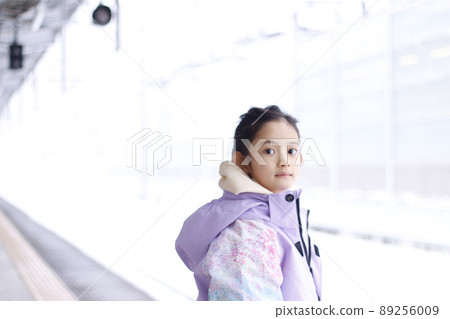 一個在冬季家庭旅行中雪天在車站站台上對雪感到滿意的女孩 一個在冬季家庭旅行中雪天在車站站台上對雪感到滿意的女孩 89256009