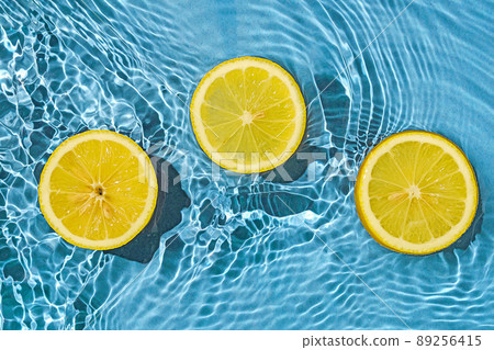 Lemon citrus tropic exotic fruit in blue transparent fresh water with motion waves. Lemon citrus tropic exotic fruit in blue transparent fresh water with motion waves. 89256415