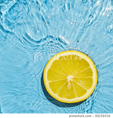 Tropics orange summer vegetarian bright juicy lemon in transparent summer blue water with wave motion. Tropics orange summer vegetarian bright juicy lemon in transparent summer blue water with wave motion. 89256416