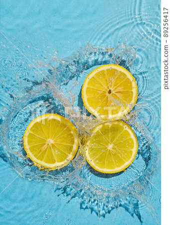 Trend contemporary concept organic juicy fresh lemon in fresh liquid water with splashes. Top view and idea of summer and health. Trend contemporary concept organic juicy fresh lemon in fresh liquid water with splashes. Top view and idea of summer and health. 89256417