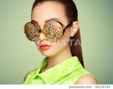 Portrait of beautiful young woman with colored glasses Portrait of beautiful young woman with colored glasses 89256764