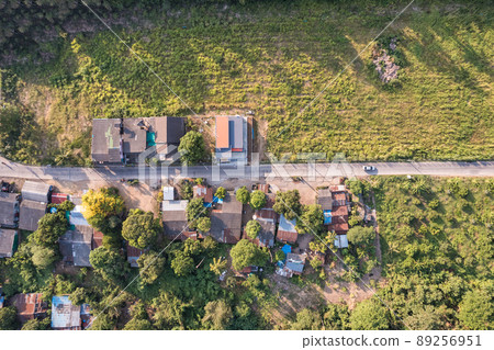 Aerial view of small town or local village among agricultural plantation in countryside Aerial view of small town or local village among agricultural plantation in countryside 89256951