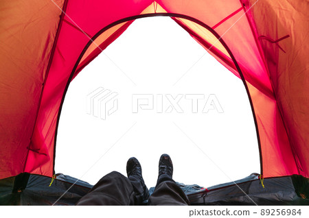 Hiker man wearing boot relaxing inside a red tent on white background Hiker man wearing boot relaxing inside a red tent on white background 89256984