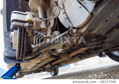 the hub of the front wheel of a jacked car during a tire change the hub of the front wheel of a jacked car during a tire change 89257366