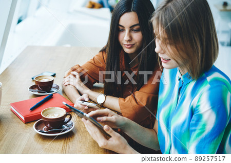Women sitting in cafe and using tablet 89257517