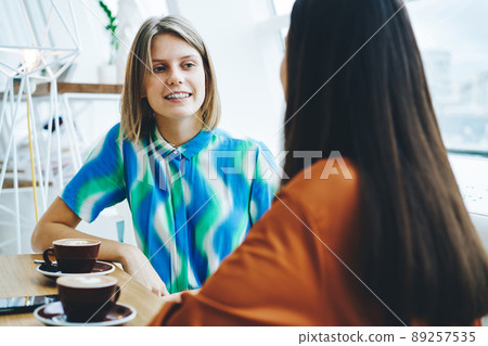 Young girlfriends spending time in cafe 89257535