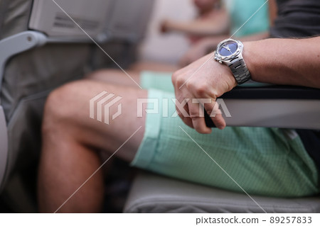 Scared man strongly grab armrest in plane Scared man strongly grab armrest in plane 89257833
