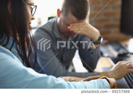 Businesswoman pointing at time to latecomer colleague 89257866